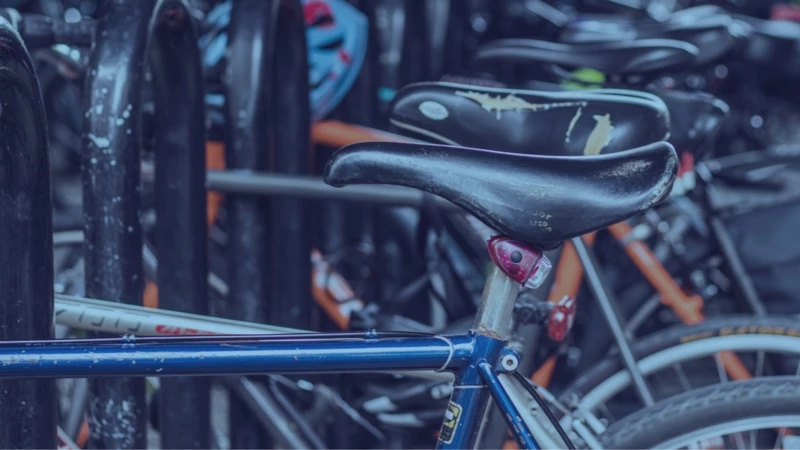 A row of bicycles are parked in a bike parking rack.