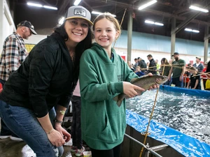 Kid with fish they just caught at the sportsmen show