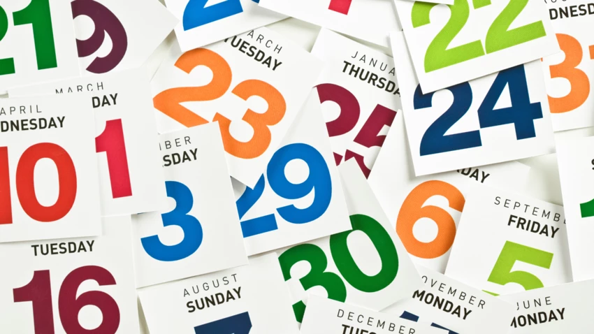 A colorful mix of single-date pages from a calendar scattered across a desktop, with month, day and date information displayed.